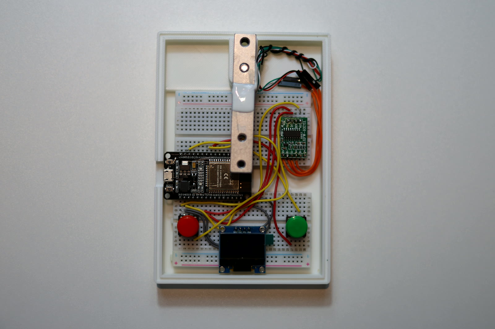 The HX711, ESP32, OLED, buttons and load cell wired up on the breadboard inside the printed case
